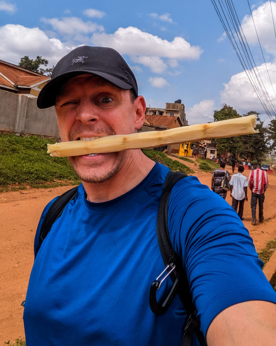 Me trying sugar cane in Uganda